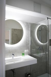 ein Bad mit einem Waschbecken und einem Spiegel in der Unterkunft Hotel Gasthof König in Kremsmünster