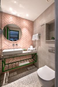 a bathroom with a sink and a mirror at Hotel Shoshana - Adults Only in Eilat