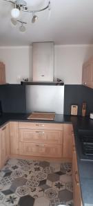 a kitchen with wooden cabinets and a black counter top at Chambre privé avec loggia chez l'habitant in Champigneulles +4 photos