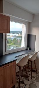 a kitchen with a window and a table and chairs at Chambre privé avec loggia chez l'habitant in Champigneulles