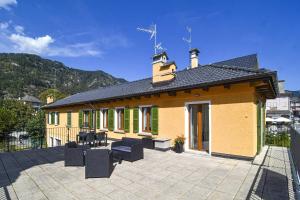 a yellow and green building with chairs and a patio at La Terrazza in Malesco