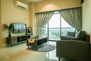 sala de estar con sofá y TV en Cosy City-View Suite in Town, en Ipoh