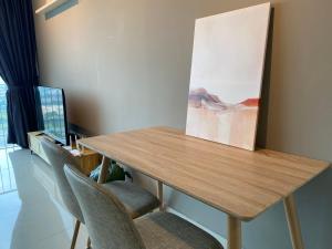 a wooden table with chairs and a painting on the wall at Trefoil Studio Comfy 3-Shah Alam in Shah Alam