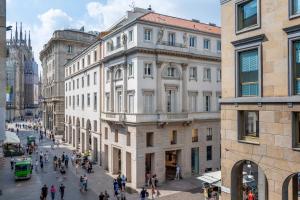 a busy street in a city with buildings at LUVI - Duomo in Milan