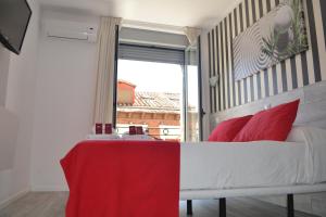 a bedroom with a bed with red pillows and a window at Hostal Madrid Sol in Madrid +53 photos