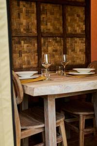 a wooden table with wine glasses and plates on it at Procida Camp & Resort - La Caravella in Procida