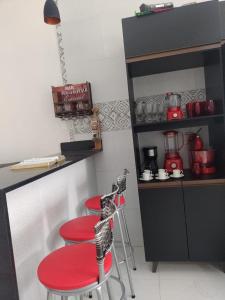 a kitchen with two red stools in front of a counter at P nacional do catimbau Buíque de 1 a 10 hospeder in Catimbau