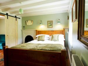 a bedroom with a large bed with a fireplace at Pass the Keys Traditional 19th C Stone Cottage in Talybont