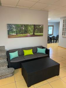 salon z czarną kanapą z żółtymi i niebieskimi poduszkami w obiekcie HOSTEL Cangas w mieście Cangas de Morrazo
