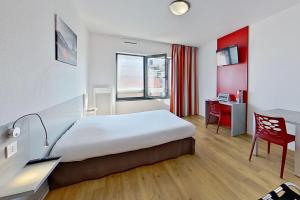 um quarto de hotel com uma cama, uma secretária e uma cadeira em City Résidence Ivry em Ivry-sur-Seine