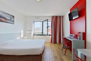 um quarto de hotel com uma cama grande e uma secretária em City Résidence Ivry em Ivry-sur-Seine