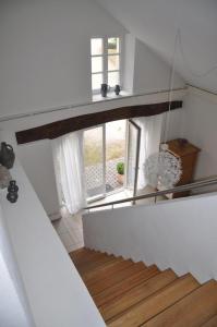 a staircase in a white room with a window at Alte Schmiede in denkmalgeschützter Hofanlage in Messerich