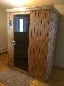einem Holzschrank mit Glastür in einem Zimmer in der Unterkunft Alte Schmiede in denkmalgeschützter Hofanlage in Messerich
