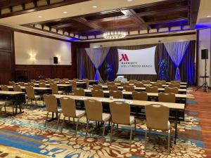 a conference room with tables and chairs in front of a screen at Hollywood Beach Marriott in Hollywood