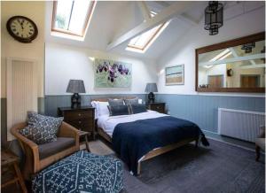 a bedroom with a bed and a clock and a chair at The Garden Studio in Dorking