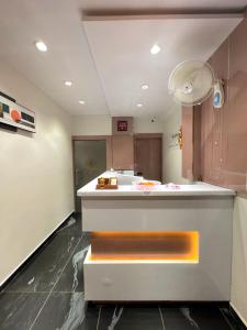 a lobby with a reception counter with an orange bench at Hotel Czar Inn in Surat