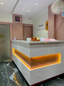 un mostrador en una tienda con naranja y blanco en Hotel Czar Inn, en Surat