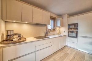 uma cozinha com armários brancos e uma bancada em High standing 6P3BR apartment - Résidence Stallion Megève em Megève
