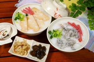 a group of bowls of food on a wooden table at Shining Motel in Taichung