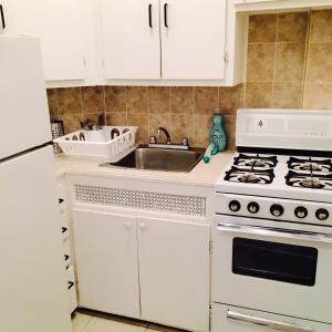 a kitchen with a white stove and a sink at Stylish Montreal Apartment: Comfortable Stay in the Golden Square Mile in Montreal