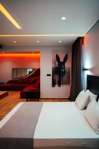 Pines Hotel في أثينا: غرفة نوم بسرير مع لوحة لأرنب على الحائط