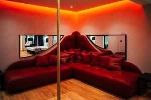 sala de estar con sofá rojo y 2 espejos en Pines Hotel, en Atenas