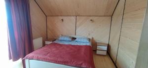 沃羅赫塔的住宿－Карпатська Модринка，木制客房内的一间卧室,配有一张床