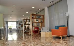 an office lobby with chairs and a book shelf at Hotel Castilla Alicante in Alicante