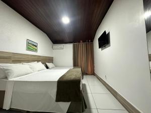 um quarto com uma cama grande num quarto em Hotel Casa Blanca Porto Seguro em Porto Seguro