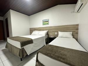um quarto com duas camas num quarto em Hotel Casa Blanca Porto Seguro em Porto Seguro