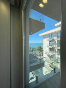 繩金塔的住宿－SACA HOTEL，窗户享有建筑和大海的景致。