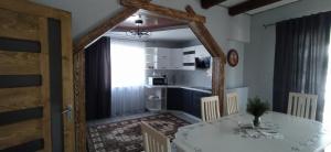 a dining room with a table and a kitchen at Карпатська Модринка in Vorokhta