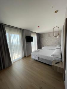 a bedroom with two beds and a flat screen tv at SACA HOTEL in Shëngjin