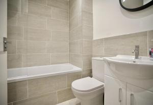 La salle de bains est pourvue de toilettes, d'un lavabo et d'une baignoire. dans l'établissement Huntingdon Luxury Apartments, à Huntingdon
