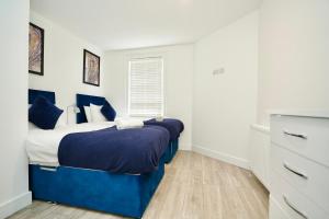 um quarto com uma cama azul e uma janela em Huntingdon Luxury Apartments em Huntingdon