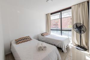 1 dormitorio con 2 camas y ventana con ventilador en Independencia Nva Cba para 6 personas en Córdoba