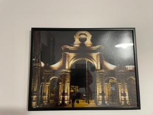a framed picture of a building on a wall at Apartament Łodzianina in Łódź