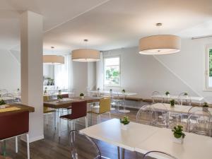a dining room with tables and chairs and lights at Hotel Ca' Mura in Bardolino
