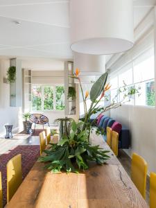 a dining room with a wooden table and yellow chairs at Hotel Ca' Mura in Bardolino