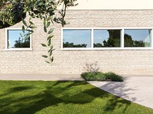 a building with windows and a grass yard at Hotel Ca' Mura in Bardolino