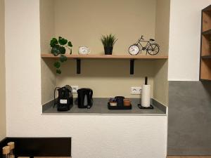 a shelf with a coffee maker and a bike on it at Europa Apartments nähe Düsseldorf Messe, Airport in Krefeld +2 photos