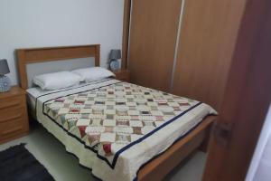 a bedroom with a bed with a quilt on it at Apt Plateau in Praia