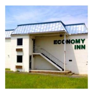 a white building with a library with a sign on it at Economy Inn of Greenville, Near ECU Health Center in Greenville