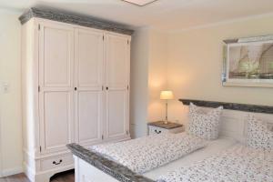 1 dormitorio con 1 cama y armario blanco grande en Villa Park Ocean, en Haffkrug