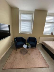 a room with two chairs and a table and a bed at Europa Apartments nähe Düsseldorf Messe, Airport in Krefeld
