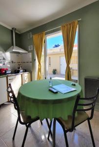 a kitchen with a green table and chairs and a window at Alquileres Grutenses in Las Grutas