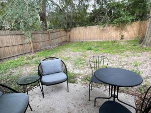 two tables and chairs in a yard with a fence at High design & coziest comforts in Gainesville