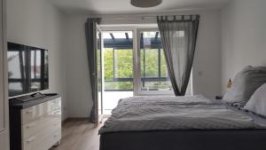 um quarto com uma cama e uma grande janela em Wohnung Meeresbrise 48 qm mit Balkon em Rostock