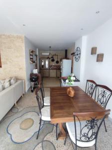 uma sala de estar com uma mesa de madeira e cadeiras em Lo Mas dei Santés em Bédarrides