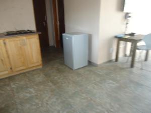 a room with a small refrigerator and a table at Noma-Nini Lodge in White River